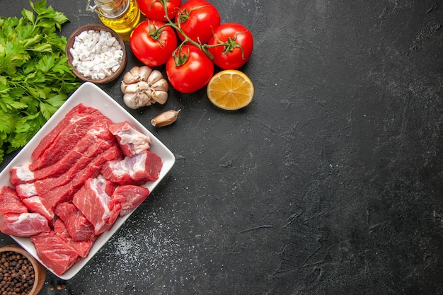 Vista dall'alto carne fresca affettata con verdure e pomodori rossi