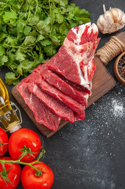 Vista dall'alto di carne fresca affettata con pomodori rossi e verdure?