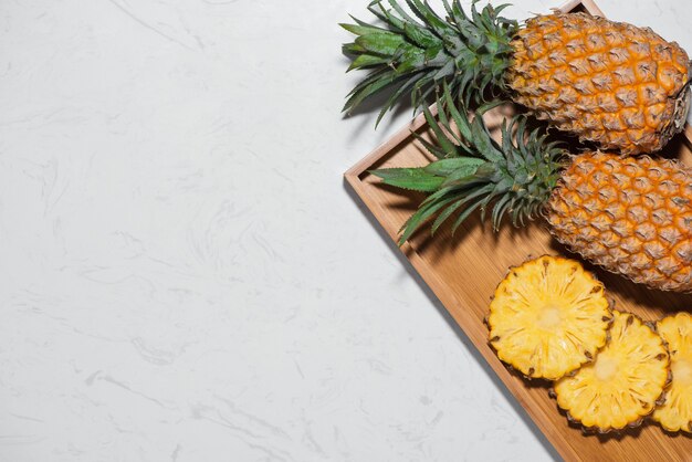 Top view of fresh sliced pineapple on a marble background.