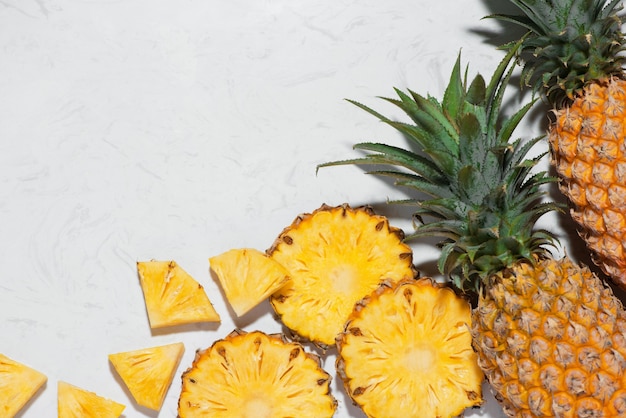 Photo top view of fresh sliced pineapple on a marble background.