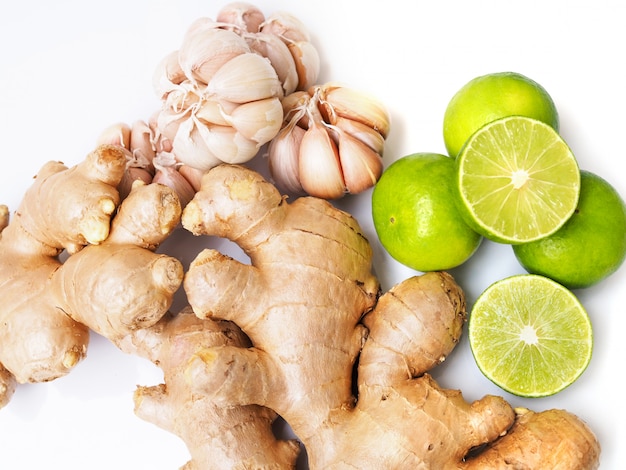 Top view of Fresh vegetables or herbs with ginger root, garlic and lemon lime citrus isolated on white surface.