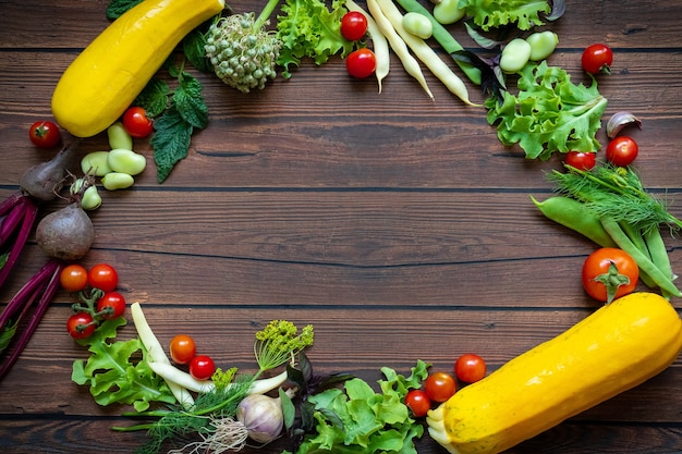 Top view of fresh vegetables placed in a circle on wooden table background with copy space