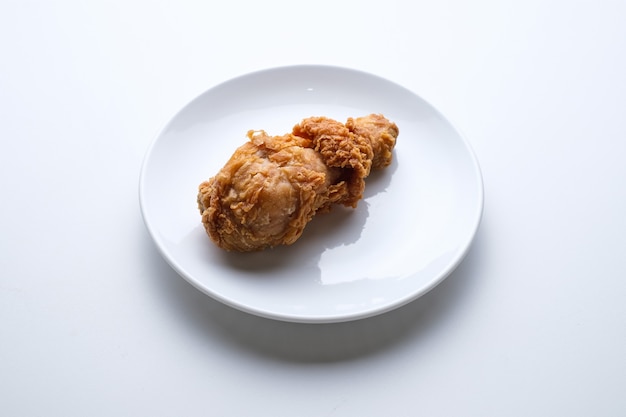 Top view fried chicken leg in white plate isolated on white