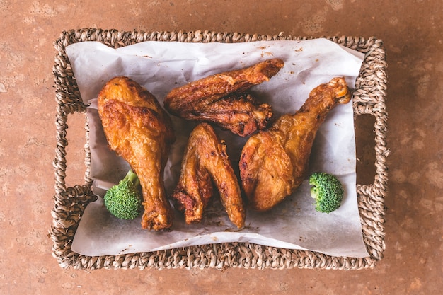 Top view of Fried chicken legs and wings in basket. 