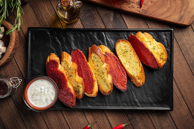 Top view on fried garlic bread toasts appetizer with sauce