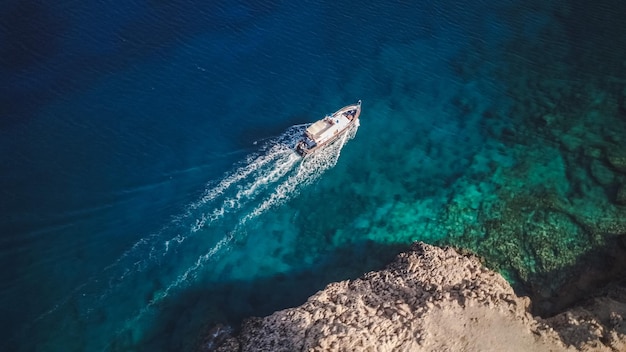 Top view from drone of speed boat in the blue water