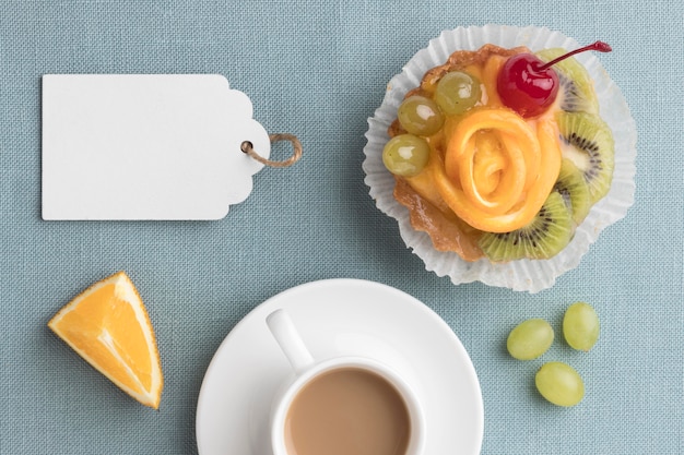 Top view of fruit tart with coffee and tag