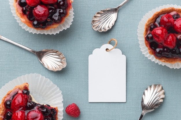 Top view of fruit tarts with tag and spoons