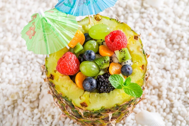 Top view of fruits salad in pineapple with cocktail umbrellas