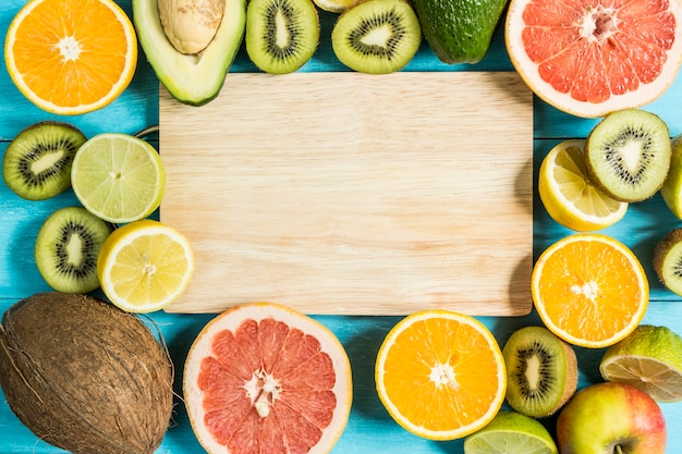 Photo top view of fruits with a board in the middle