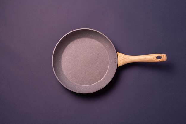 A top view of a frying pan cooking utensil on pastel background