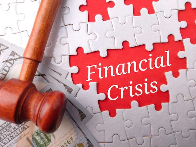 Top view gavel and banknotes with text Financial Crisis on puzzle background