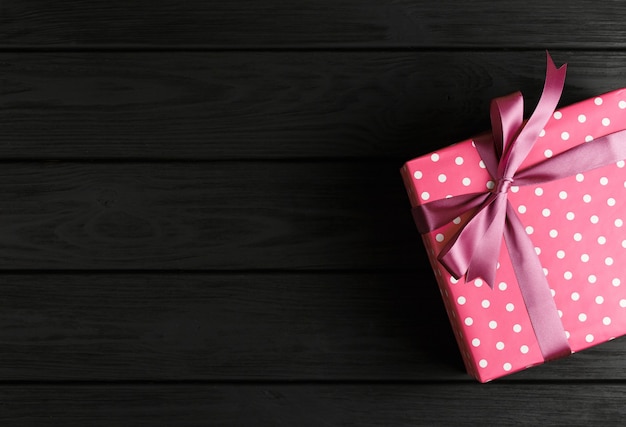 Top view of a gift box on a black wooden wall, gifts on a black table a flat lay, a festive concept