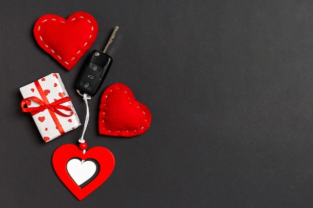 Top view of gift box, car key, wooden and textile hearts