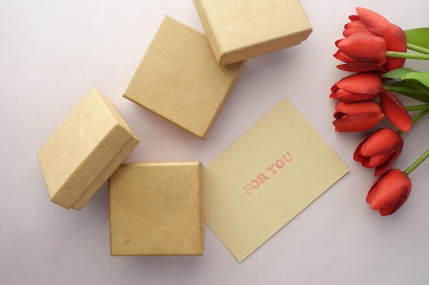Top view of gift box and rose flower on color background