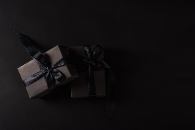 Photo top view of gift box wrapped in black paper and black ribbon