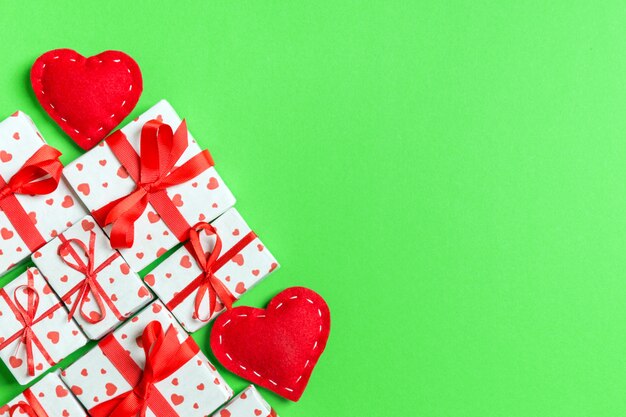 Top view of gift boxes and red textile hearts on green