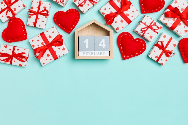 Top view of gift boxes, wooden calendar and red textile hearts