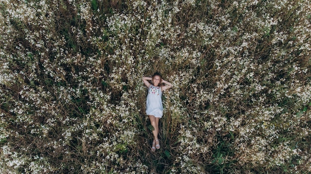 A top view of a girl lying in a flower field and relaxing