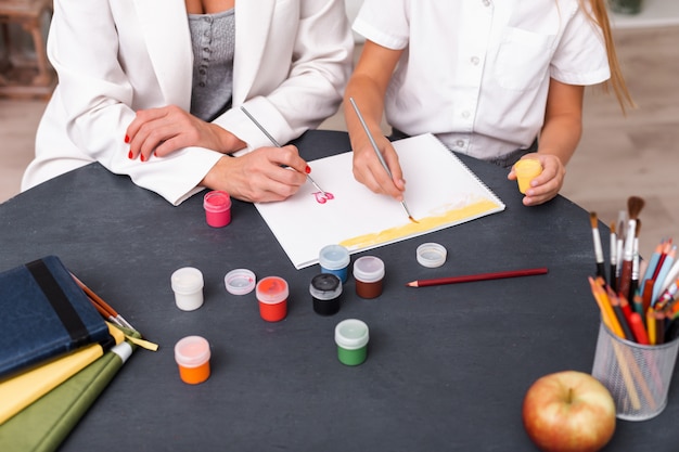 Top view, girl and mother paint with paints