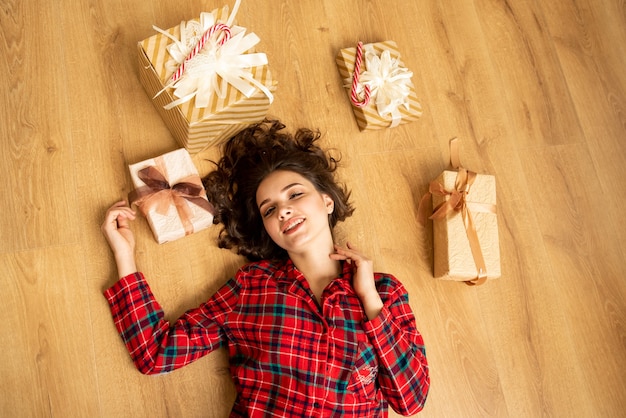 Photo top view of the girl. she lying on the floor with presents. christmas. new year