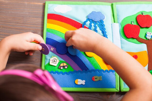 Top view of the girl who is laying out circles for rainbow colors in the quiet book