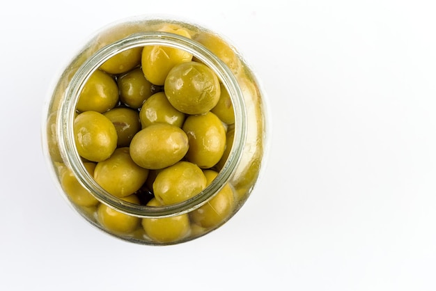 Photo top view of glass jar with green olives.