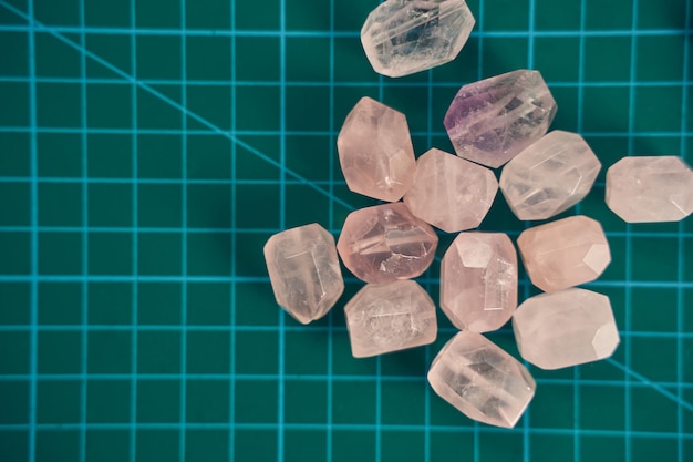 Top view of glass seed and bugle beads or amethyst and turmaline stones isolated on the green background