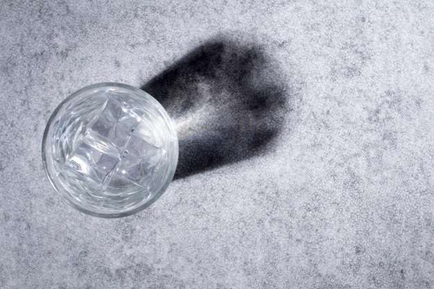 Top view of glass with ice cubes and water projecting a reflexion