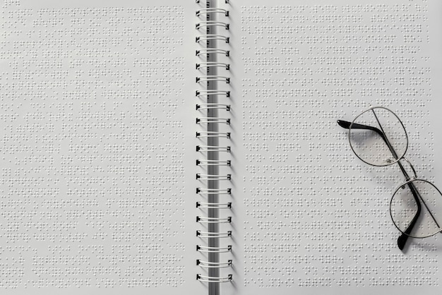 Photo top view glasses on braille notebook