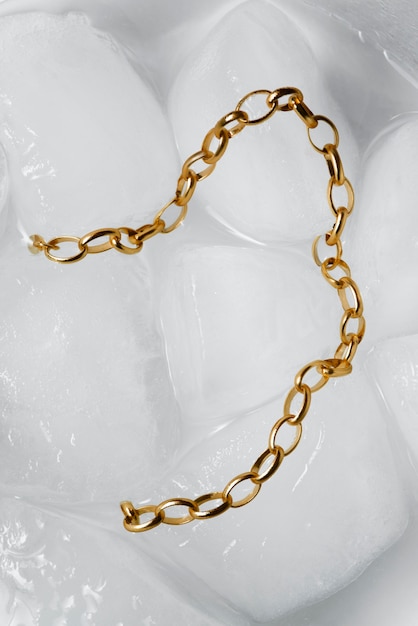 Photo top view gold chain on ice cubes