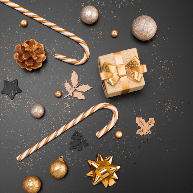 Top view of golden christmas ornaments with present and candy canes