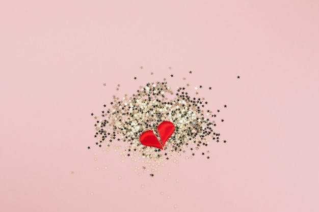 Top view of golden stars confetti broken heart