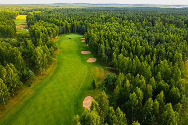 Top view of the golf course located in a wooded area