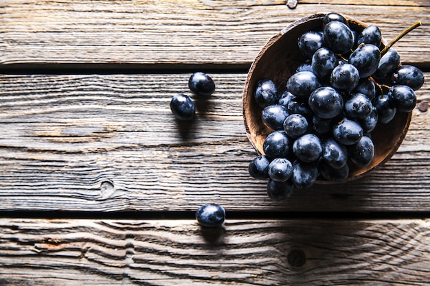 Top view of grapes in wicker basket on wooden table. fruits