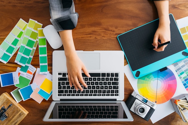 Foto vista dall'alto del graphic designer lavorando con la tavoletta grafica e il computer portatile