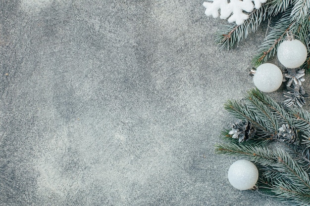 Vista dall'alto di uno sfondo di cemento grigio natale decorato con rami di un albero di natale con decorazioni natalizie pigne con spazio libero per il testo