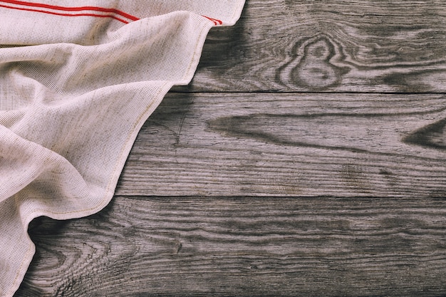 Top view of a gray napkin on the left side of a wooden table