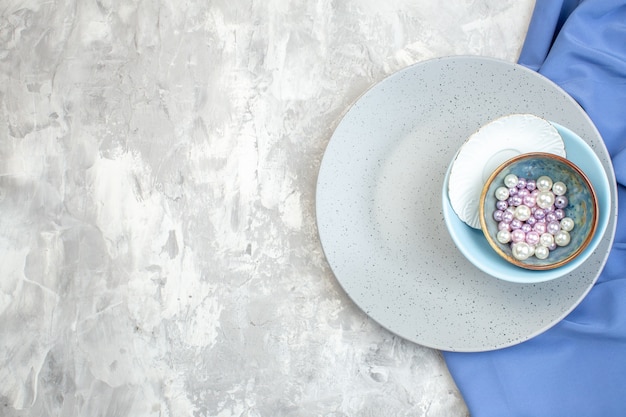 top view gray plate with little blue plate and beads on light surface kitchen ladies food femininity glass meal colour