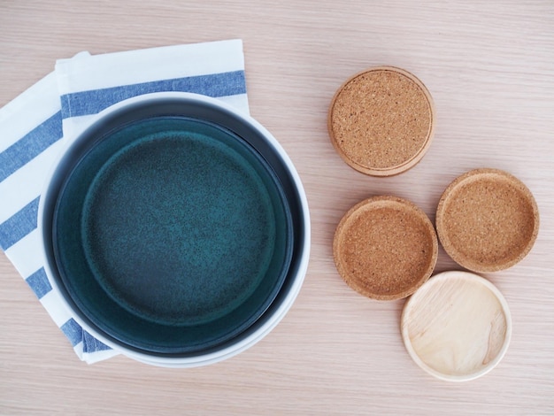 Top view of green ceramic plate Cork coasters and placemats on table