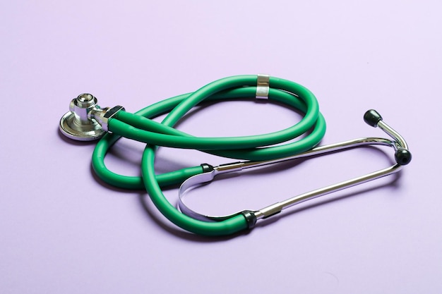 Top view of green medical stethoscope on colorful background\
with copy space medicine equipment concept