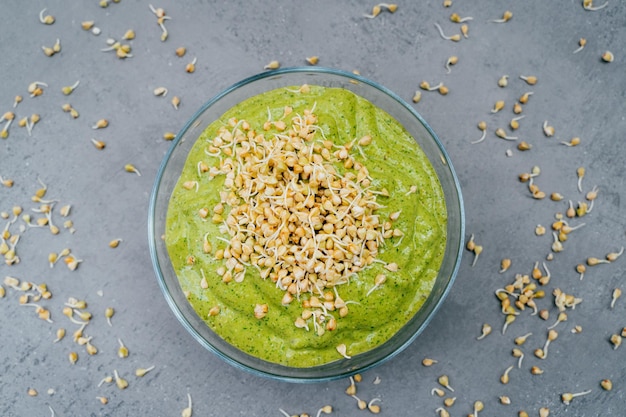 Top view of green smoothie dish in bowl with green buckwheat sprouts Healthy breakfast Vegetable dish Meal full of vitamins Super bowl