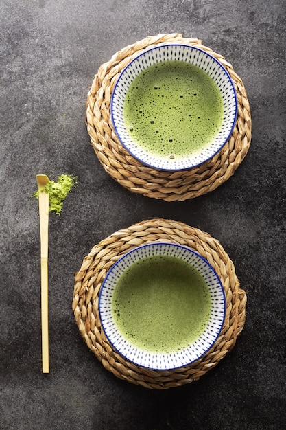 暗いテーブルのボウルに抹茶抹茶のトップビュー