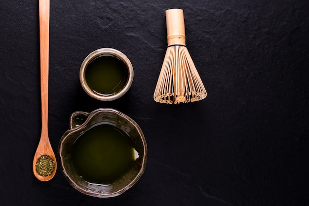 Top view of green tea matcha in a bowl on wooden surface