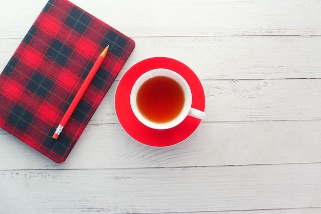 Top view of green tea and notepad on wooden table