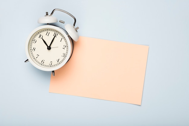 Top view greeting card and clock on table