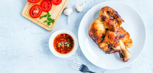 Top view of grilled chicken menu with chilli sauce on white wooden background