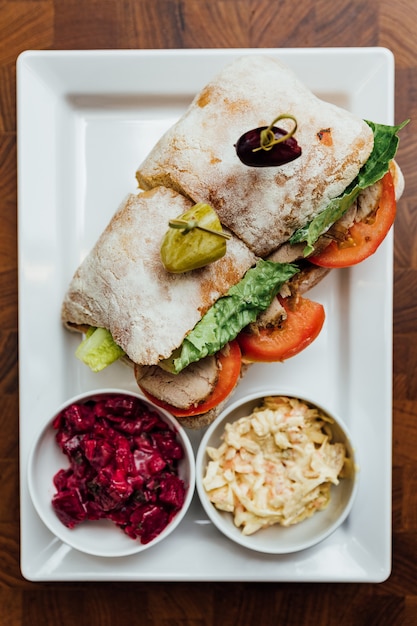 Top view of Grilled chicken sandwich made with homemade bread, tomato and lettuce.