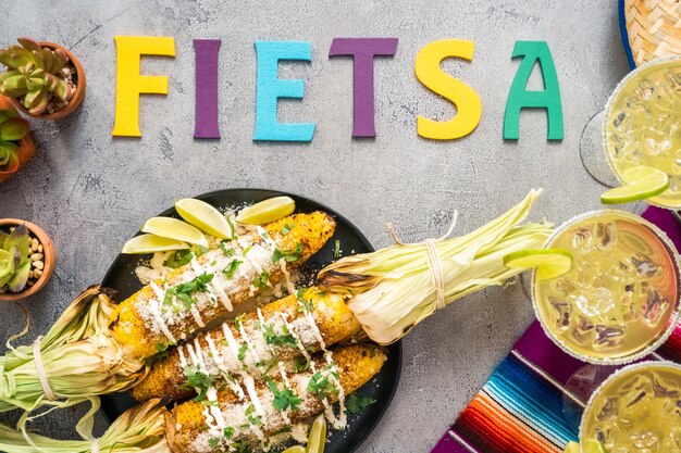 Top view. Grilling mexican street corn elote garnished with spices on a serving plate.