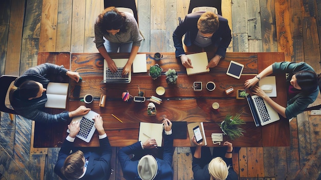 Top view of a group of business professionals working together at a wooden table